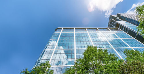 Low angle view of modern building against blue sky