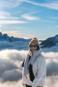 Portrait of young woman standing against sky