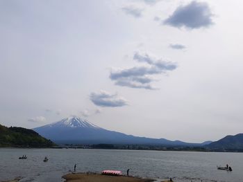 Scenic view of lake by mountains against sky