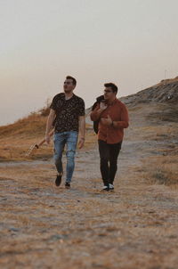 Full length of young man with sunglasses against clear sky