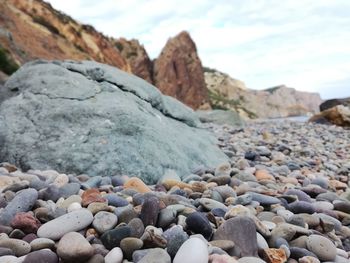 Surface level of pebbles on beach against sky
