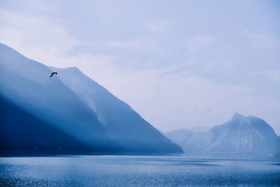 Scenic view of sea and mountains against sky