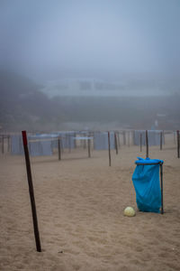 Wooden chairs on beach against sky