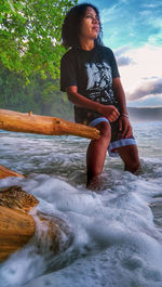 Full length of man sitting on sea shore