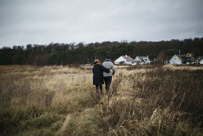 Couple walking through meadow