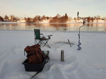 Rear view of man sitting on snow covered field