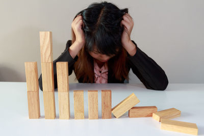 Frustrated woman with wooden blocks on table