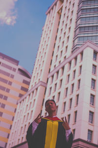 Low angle view of man standing against building in city