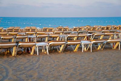 Chairs on beach against sky