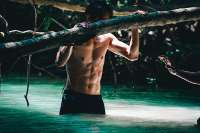 Midsection of shirtless man in  pool