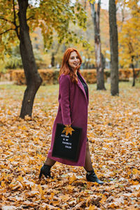 Hello autumn. red hair girl with letter message board with text autumn is my favorite color