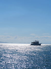 Ship sailing in sea against blue sky