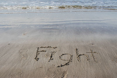 High angle view of text on sand at beach