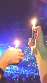 Close-up of hand holding lit candle