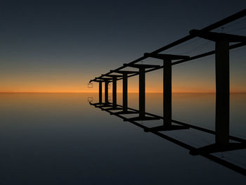 Built structure over sea during sunset