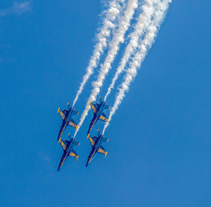 Low angle view of airplane against blue sky