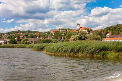 Scenic view of river by town against sky