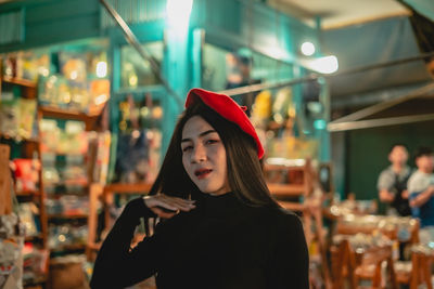 Portrait of young woman looking at illuminated camera