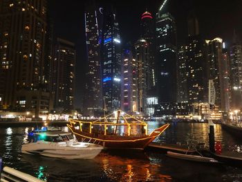 Illuminated buildings by river at night