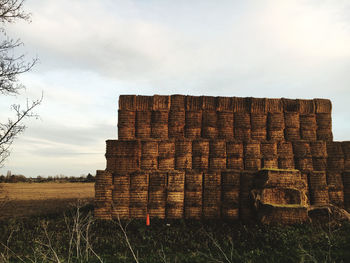 Stone wall on field against sky