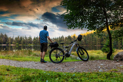 A cycle tourist enjoys the evening atmosphere at feldsee in the black forest