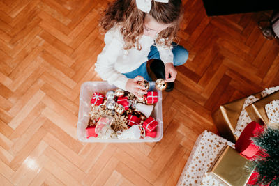 High angle view of girl holding decoration at home