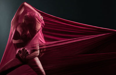 Midsection of woman with red light against colored background