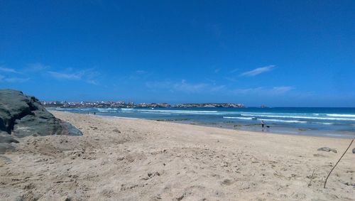 Scenic view of beach against blue sky