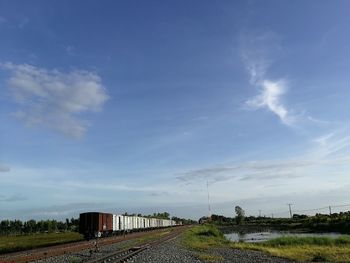 Railroad tracks on field against sky