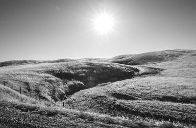 Scenic view of landscape against bright sun