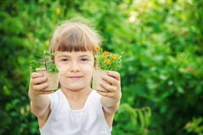 Portrait of woman holding potted plant