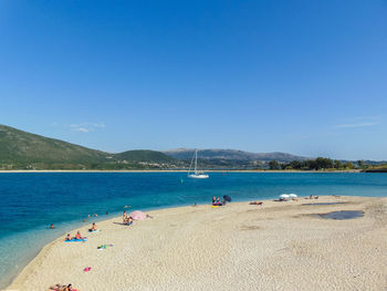 Scenic view of beach against clear blue sky