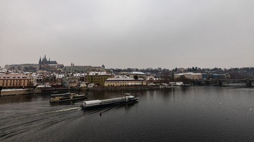 River amidst buildings in city against sky