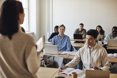 Multiracial students attending lecture in classroom at university