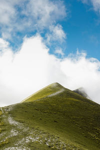 Low angle view of mountain against cloudy sky