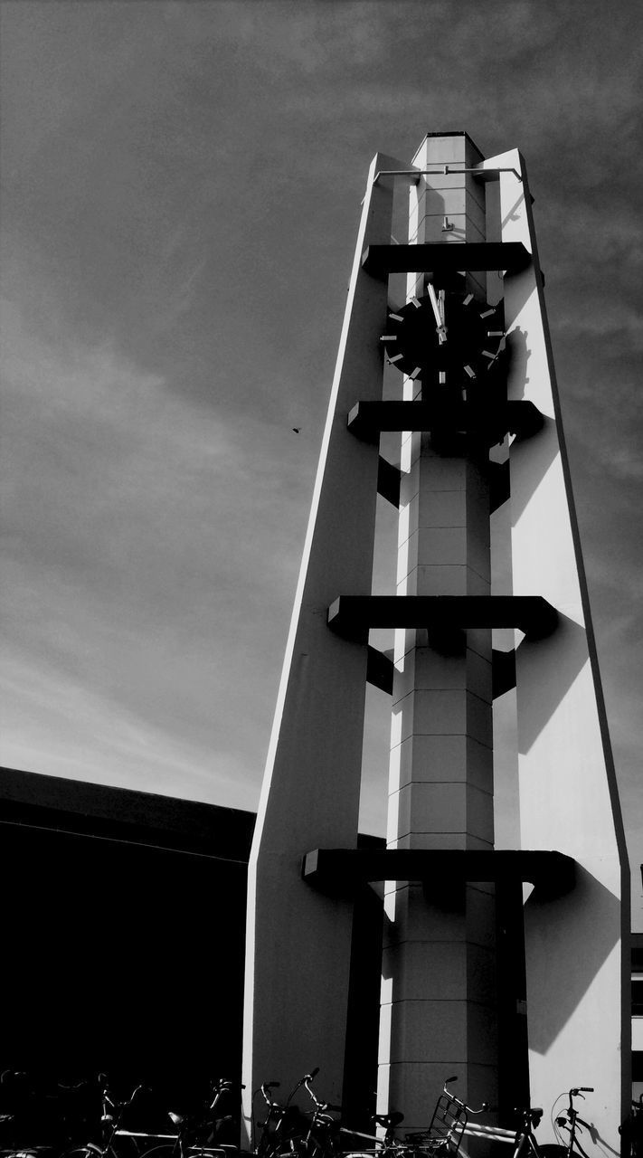 low angle view, architecture, built structure, building exterior, sky, tower, tall - high, silhouette, modern, cloud - sky, city, building, outdoors, no people, skyscraper, lighting equipment, day, office building, cloud, street light