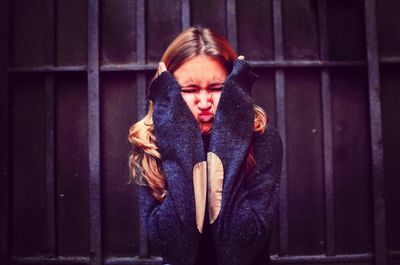 Woman squeezing cheeks against wall