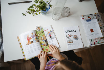 High angle of girl reading book