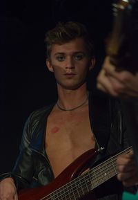 Portrait of male guitarist with lipstick kiss on chest