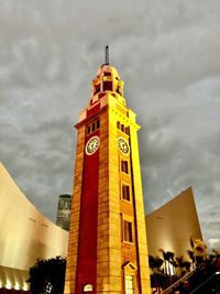 Low angle view of buildings in city against cloudy sky