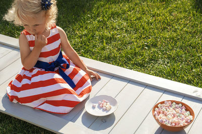 High angle view of girl sitting on grass