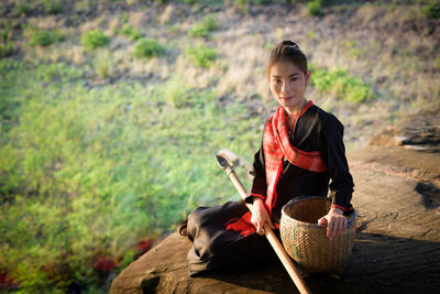 Portrait of mid adult woman with wicker basket in forest