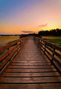 Pier over sea against sky during sunset