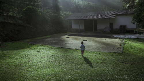 Full length of boy walking by house against building