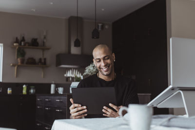 Man using phone while sitting on table