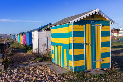 Built structure on beach by houses against blue sky