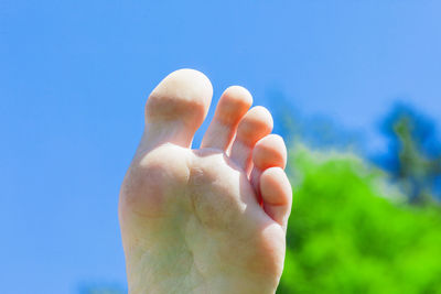 Close-up of leg against sky