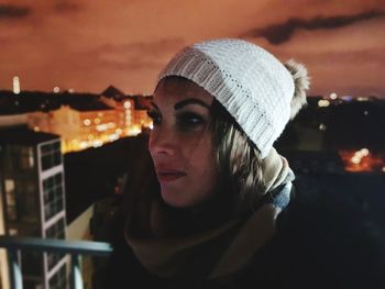 Close-up of young woman against sky at night