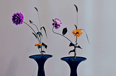 Close-up of flowering plant in vase against wall