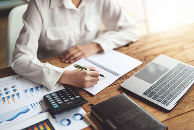 Midsection of business person working at desk in office